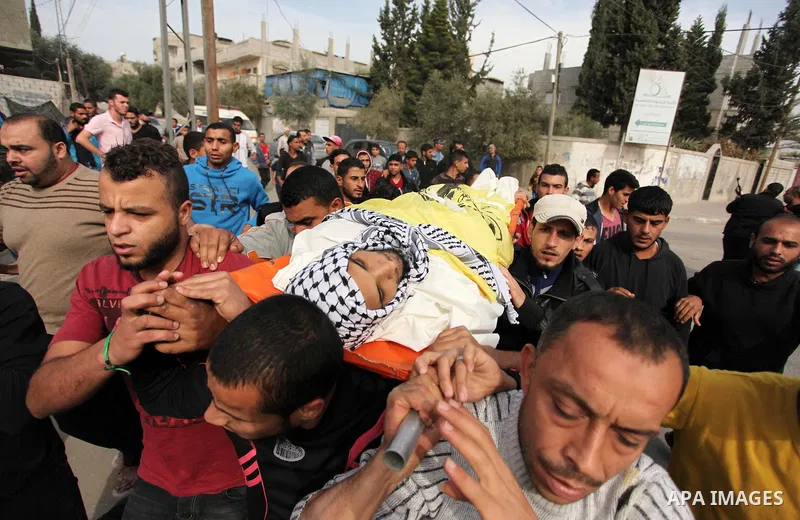 Mourners carry the body of Mohammed Abu Saada, a 26-year-old Palestinian man who was reportedly killed in clashes with the Israeli army along the Gaza border, during his funeral in the Nuseirat refugee camp in the centra...