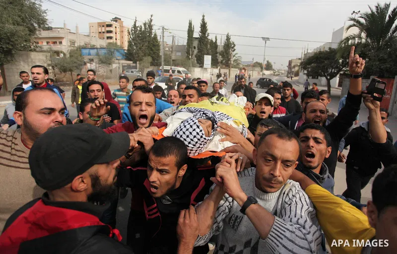 Mourners carry the body of Mohammed Abu Saada, a 26-year-old Palestinian man who was reportedly killed in clashes with the Israeli army along the Gaza border, during his funeral in the Nuseirat refugee camp in the centra...
