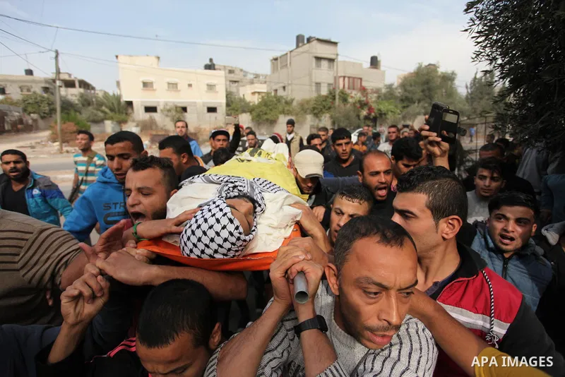 Mourners carry the body of Mohammed Abu Saada, a 26-year-old Palestinian man who was reportedly killed in clashes with the Israeli army along the Gaza border, during his funeral in the Nuseirat refugee camp in the centra...