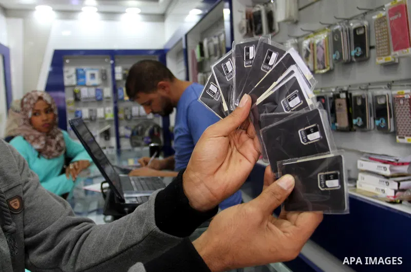 A Palestinian man displays SIM cards of Cellcom and Partner from Israeli cellular providers, in a mobile phone shop in Rafah in the southern Gaza strip, on November 20, 2016. Interior Ministry in Gaza are trying to stop...