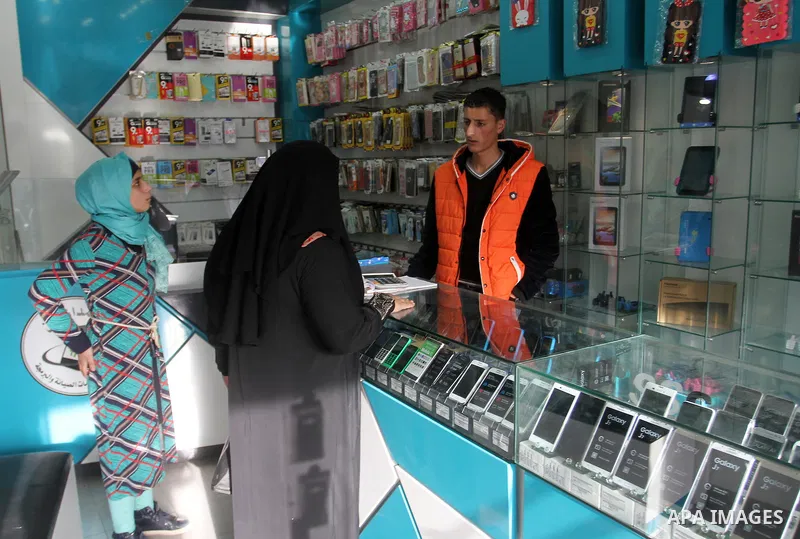 A Palestinian man work at his mobile phone shop in Rafah in the southern Gaza strip, on November 20, 2016. Interior Ministry in Gaza are trying to stop the sale and distribution of pre-paid SIM cards from Israeli cellula...