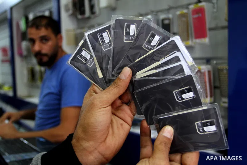 A Palestinian man displays SIM cards of Cellcom and Partner from Israeli cellular providers, in a mobile phone shop in Rafah in the southern Gaza strip, on November 20, 2016. Interior Ministry in Gaza are trying to stop...