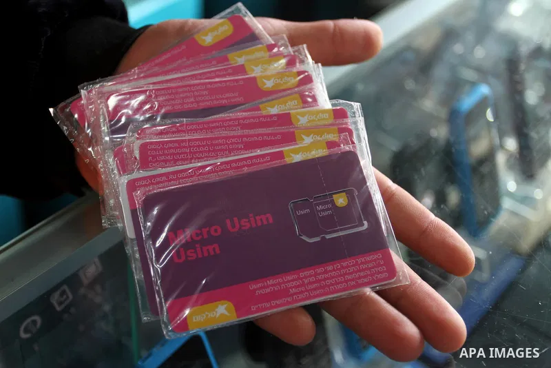 A Palestinian man displays SIM cards of Cellcom and Partner from Israeli cellular providers, in a mobile phone shop in Rafah in the southern Gaza strip, on November 20, 2016. Interior Ministry in Gaza are trying to stop...