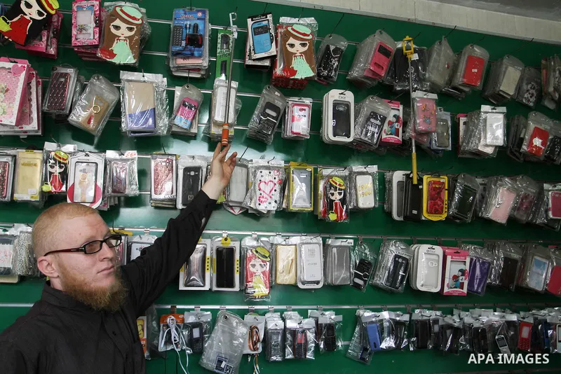 A Palestinian man work at his mobile phone shop in Rafah in the southern Gaza strip, on November 20, 2016. Interior Ministry in Gaza are trying to stop the sale and distribution of pre-paid SIM cards from Israeli cellula...