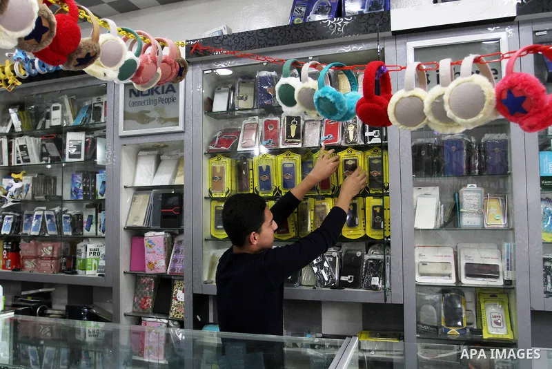 A Palestinian man work at his mobile phone shop in Rafah in the southern Gaza strip, on November 20, 2016. Interior Ministry in Gaza are trying to stop the sale and distribution of pre-paid SIM cards from Israeli cellula...