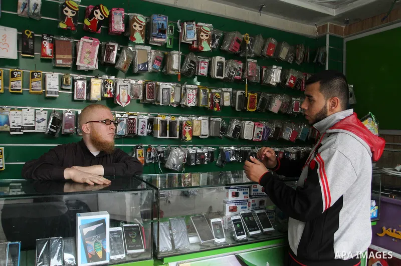 A Palestinian man work at his mobile phone shop in Rafah in the southern Gaza strip, on November 20, 2016. Interior Ministry in Gaza are trying to stop the sale and distribution of pre-paid SIM cards from Israeli cellula...