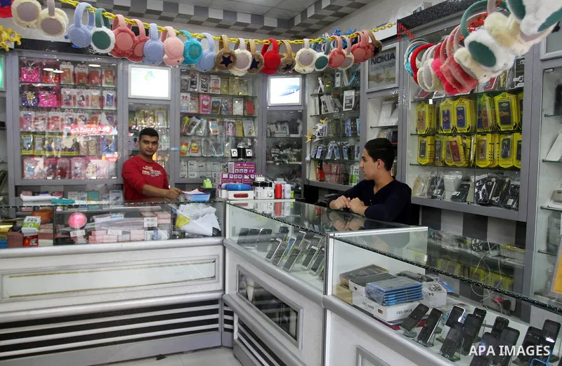 A Palestinian man work at his mobile phone shop in Rafah in the southern Gaza strip, on November 20, 2016. Interior Ministry in Gaza are trying to stop the sale and distribution of pre-paid SIM cards from Israeli cellula...