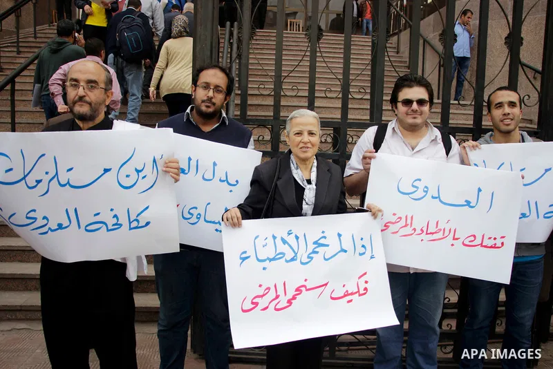 Egyptian doctors hold banners during a protest against shortage of medical supplies, outside the State Council's building, Egypt's highest administrative court, in Cairo on Nov. 20, 2016. Doctors are being told to reuse...