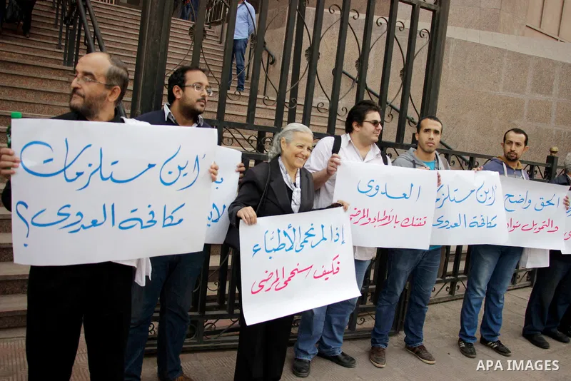 Egyptian doctors hold banners during a protest against shortage of medical supplies, outside the State Council's building, Egypt's highest administrative court, in Cairo on Nov. 20, 2016. Doctors are being told to reuse...