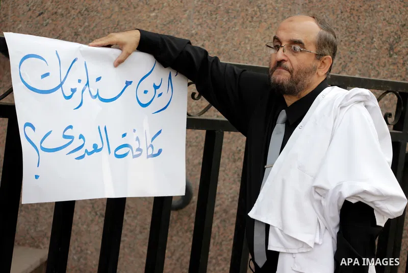 Egyptian doctors hold banners during a protest against shortage of medical supplies, outside the State Council's building, Egypt's highest administrative court, in Cairo on Nov. 20, 2016. Doctors are being told to reuse...