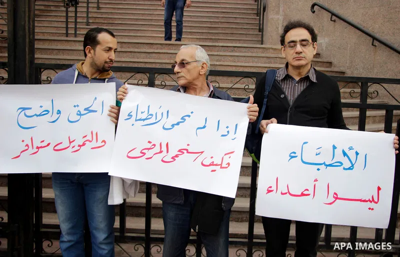 Egyptian doctors hold banners during a protest against shortage of medical supplies, outside the State Council's building, Egypt's highest administrative court, in Cairo on Nov. 20, 2016. Doctors are being told to reuse...