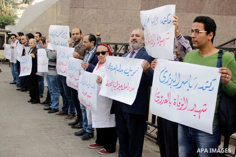 Egyptian doctors hold banners during a protest against shortage of medical supplies, outside the State Council's building, Egypt's highest administrative court, in Cairo on Nov. 20, 2016. Doctors are being told to reuse...