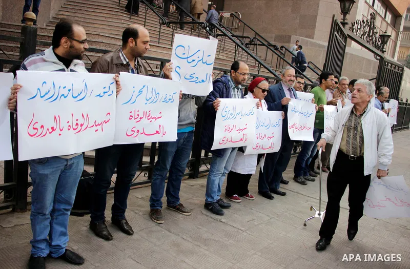 Egyptian doctors hold banners during a protest against shortage of medical supplies, outside the State Council's building, Egypt's highest administrative court, in Cairo on Nov. 20, 2016. Doctors are being told to reuse...