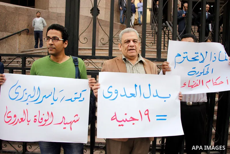 Egyptian doctors hold banners during a protest against shortage of medical supplies, outside the State Council's building, Egypt's highest administrative court, in Cairo on Nov. 20, 2016. Doctors are being told to reuse...