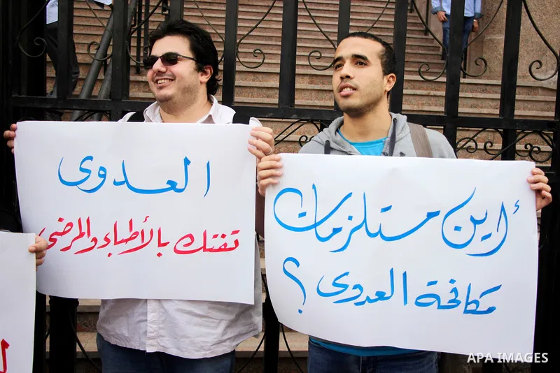 Egyptian doctors hold banners during a protest against shortage of medical supplies, outside the State Council's building, Egypt's highest administrative court, in Cairo on Nov. 20, 2016. Doctors are being told to reuse...
