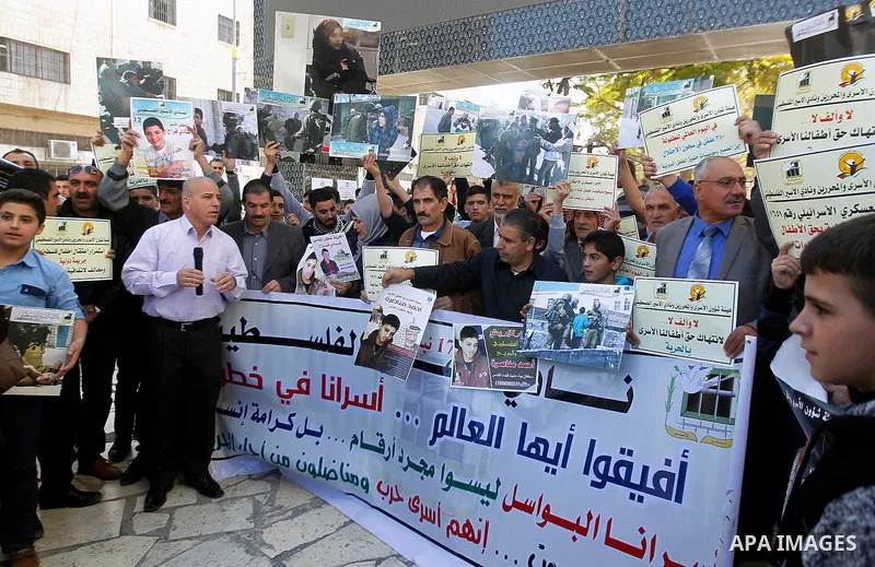 Palestinians hold banners during a protest to show solidarity with children prisoners in Israeli jails, in the West Bank city of Hebron, on November 21, 2016. Photo by Wisam Hashlamoun