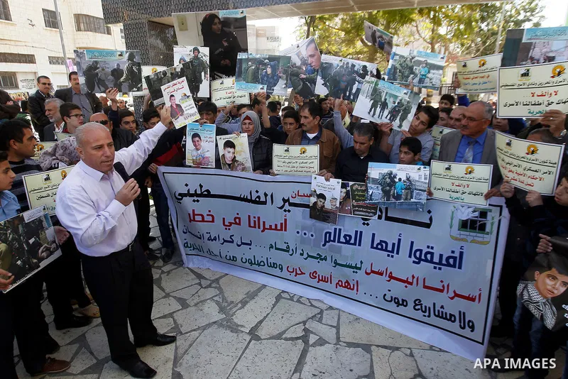 Palestinians hold banners during a protest to show solidarity with children prisoners in Israeli jails, in the West Bank city of Hebron, on November 21, 2016. Photo by Wisam Hashlamoun