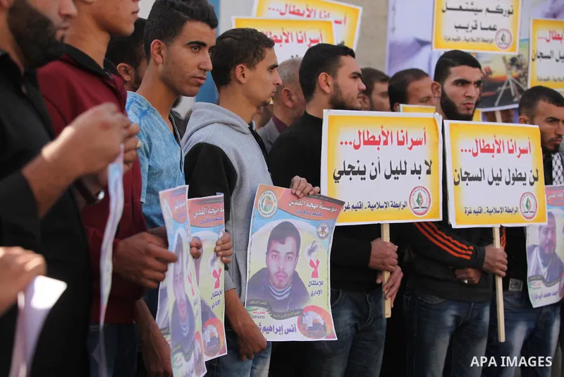 Palestinians hold banners during a protest to show solidarity with Palestinian prisoners on hunger strike in Israeli Jails, in front of the high commissioner for human rights headquarters in Gaza City, on November 22, 20...
