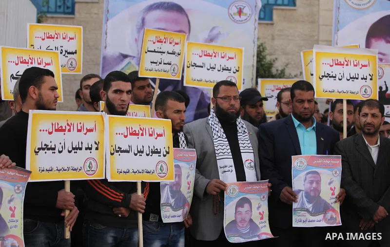 Palestinians hold banners during a protest to show solidarity with Palestinian prisoners on hunger strike in Israeli Jails, in front of the high commissioner for human rights headquarters in Gaza City, on November 22, 20...