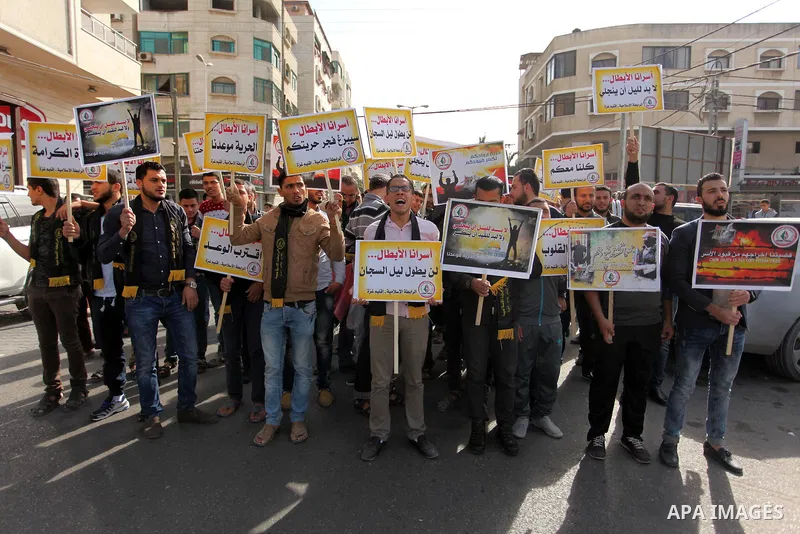 Palestinians hold banners during a protest to show solidarity with Palestinian prisoners on hunger strike in Israeli Jails, in front of the high commissioner for human rights headquarters in Gaza City, on November 22, 20...