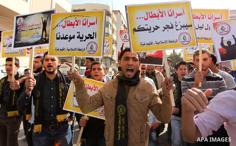 Palestinians hold banners during a protest to show solidarity with Palestinian prisoners on hunger strike in Israeli Jails, in front of the high commissioner for human rights headquarters in Gaza City, on November 22, 20...