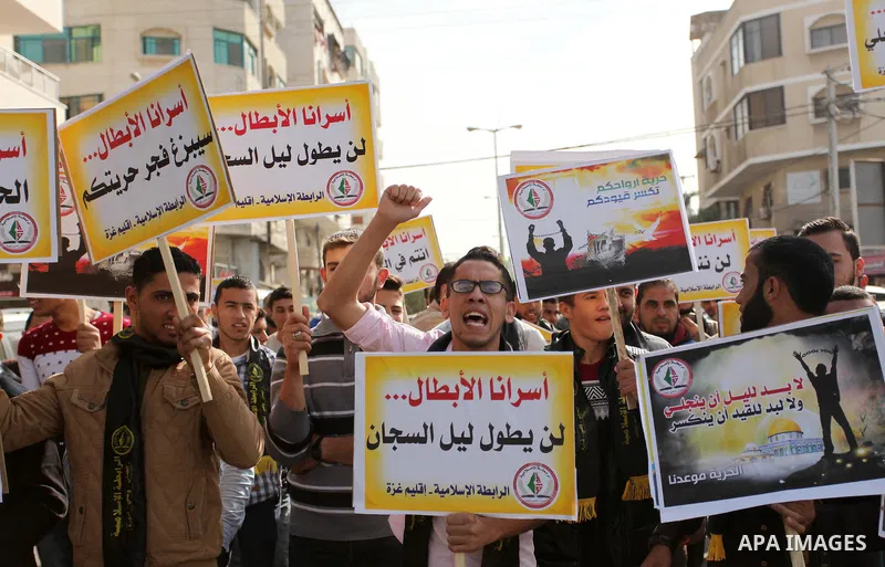 Palestinians hold banners during a protest to show solidarity with Palestinian prisoners on hunger strike in Israeli Jails, in front of the high commissioner for human rights headquarters in Gaza City, on November 22, 20...