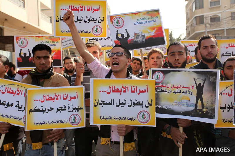 Palestinians hold banners during a protest to show solidarity with Palestinian prisoners on hunger strike in Israeli Jails, in front of the high commissioner for human rights headquarters in Gaza City, on November 22, 20...