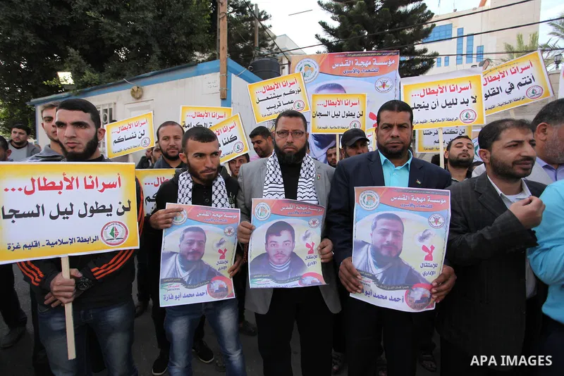 Palestinians hold banners during a protest to show solidarity with Palestinian prisoners on hunger strike in Israeli Jails, in front of the high commissioner for human rights headquarters in Gaza City, on November 22, 20...