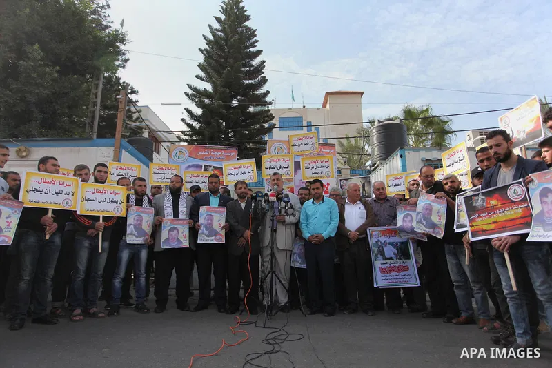 Palestinians hold banners during a protest to show solidarity with Palestinian prisoners on hunger strike in Israeli Jails, in front of the high commissioner for human rights headquarters in Gaza City, on November 22, 20...