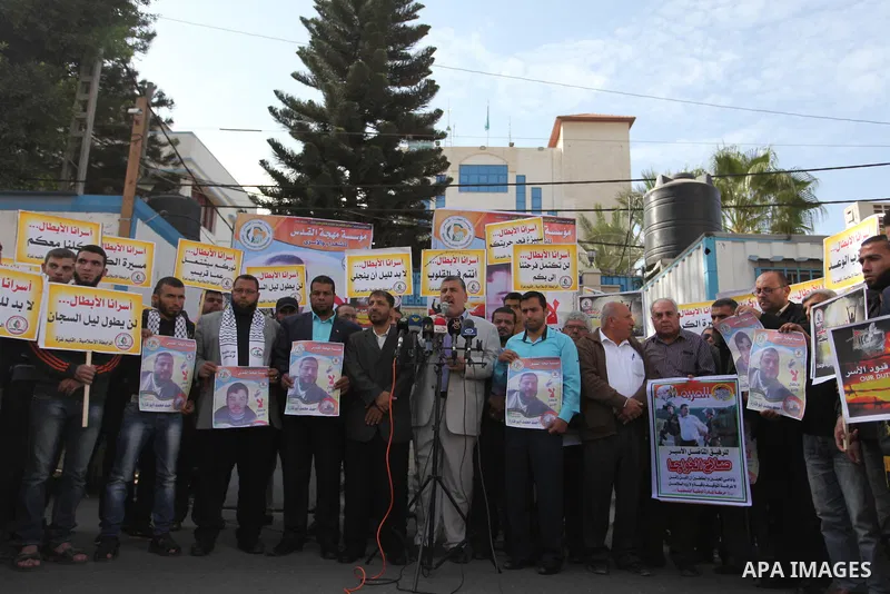 Palestinians hold banners during a protest to show solidarity with Palestinian prisoners on hunger strike in Israeli Jails, in front of the high commissioner for human rights headquarters in Gaza City, on November 22, 20...