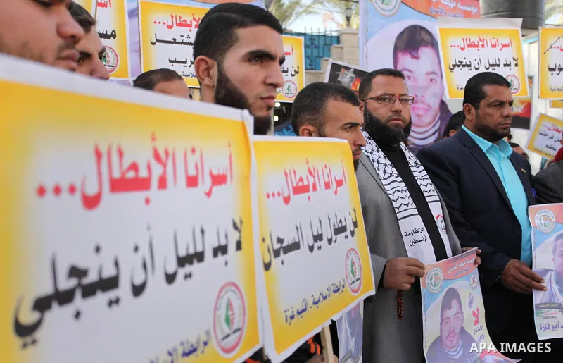 Palestinians hold banners during a protest to show solidarity with Palestinian prisoners on hunger strike in Israeli Jails, in front of the high commissioner for human rights headquarters in Gaza City, on November 22, 20...