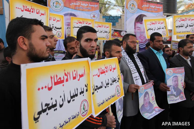 Palestinians hold banners during a protest to show solidarity with Palestinian prisoners on hunger strike in Israeli Jails, in front of the high commissioner for human rights headquarters in Gaza City, on November 22, 20...