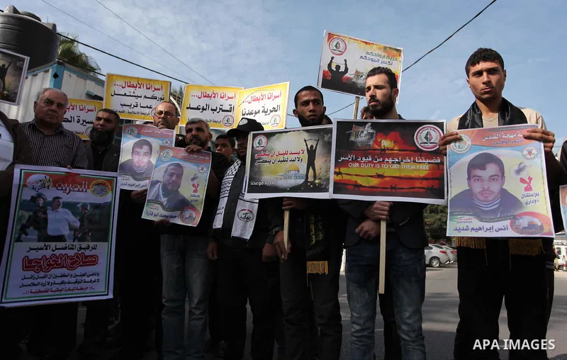 Palestinians hold banners during a protest to show solidarity with Palestinian prisoners on hunger strike in Israeli Jails, in front of the high commissioner for human rights headquarters in Gaza City, on November 22, 20...