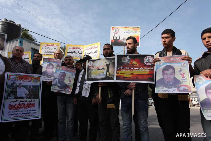 Palestinians hold banners during a protest to show solidarity with Palestinian prisoners on hunger strike in Israeli Jails, in front of the high commissioner for human rights headquarters in Gaza City, on November 22, 20...
