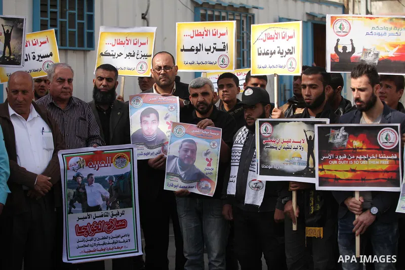 Palestinians hold banners during a protest to show solidarity with Palestinian prisoners on hunger strike in Israeli Jails, in front of the high commissioner for human rights headquarters in Gaza City, on November 22, 20...