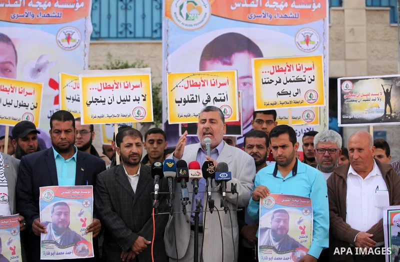 Palestinians hold banners during a protest to show solidarity with Palestinian prisoners on hunger strike in Israeli Jails, in front of the high commissioner for human rights headquarters in Gaza City, on November 22, 20...