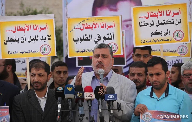 Palestinians hold banners during a protest to show solidarity with Palestinian prisoners on hunger strike in Israeli Jails, in front of the high commissioner for human rights headquarters in Gaza City, on November 22, 20...