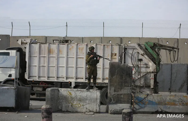 Israeli security forces gather at the site where a Palestinian was shot dead after allegedly walking towards guards wielding a knife at the Qalandia checkpoint crossing between the West Bank city of Ramallah and Israeli-...