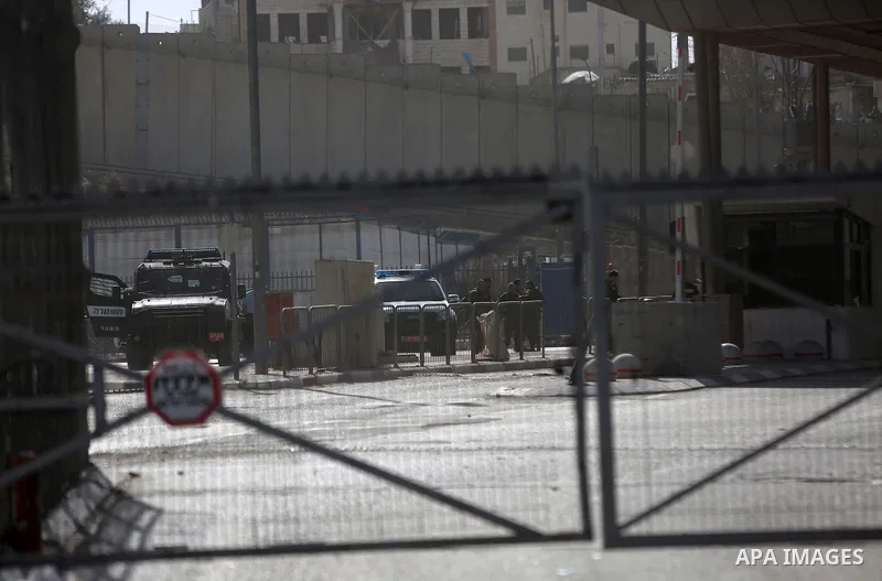 Israeli security forces gather at the site where a Palestinian was shot dead after allegedly walking towards guards wielding a knife at the Qalandia checkpoint crossing between the West Bank city of Ramallah and Israeli-...