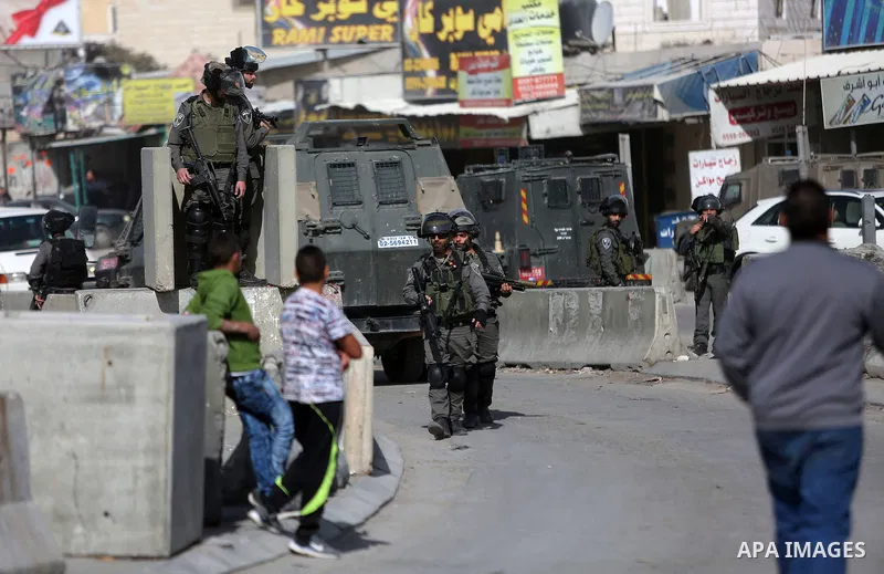 Israeli security forces gather at the site where a Palestinian was shot dead after allegedly walking towards guards wielding a knife at the Qalandia checkpoint crossing between the West Bank city of Ramallah and Israeli-...