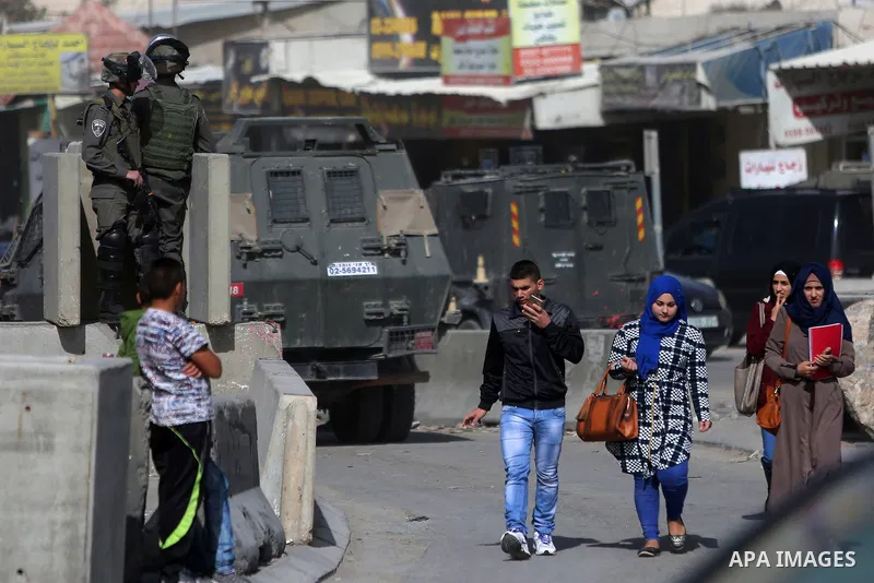 Israeli security forces gather at the site where a Palestinian was shot dead after allegedly walking towards guards wielding a knife at the Qalandia checkpoint crossing between the West Bank city of Ramallah and Israeli-...