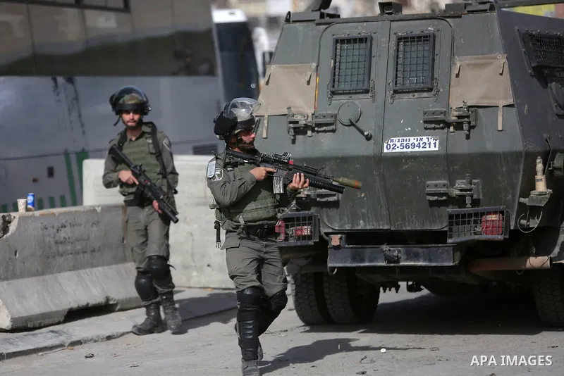 Israeli security forces gather at the site where a Palestinian was shot dead after allegedly walking towards guards wielding a knife at the Qalandia checkpoint crossing between the West Bank city of Ramallah and Israeli-...