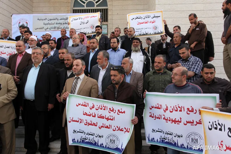 Palestinians hold banners during a protest against a controversial Israeli bill to limit the volume of calls to prayer at mosques in the occupied Jerusalem, in Gaza city on November 23, 2016. Israeli Prime Minister Benja...