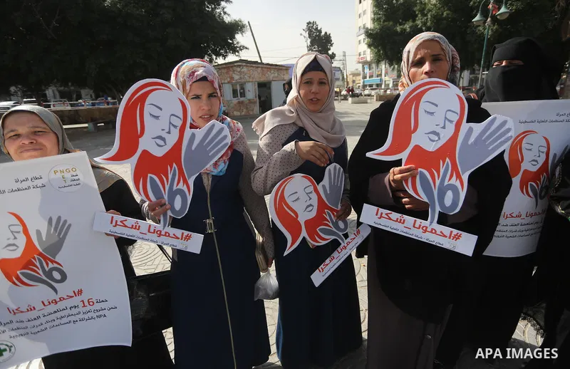 Palestinian women hold banners during international campaign against violence against women, in Gaza City, on November 24, 2016. Photo by Mohammed Asad