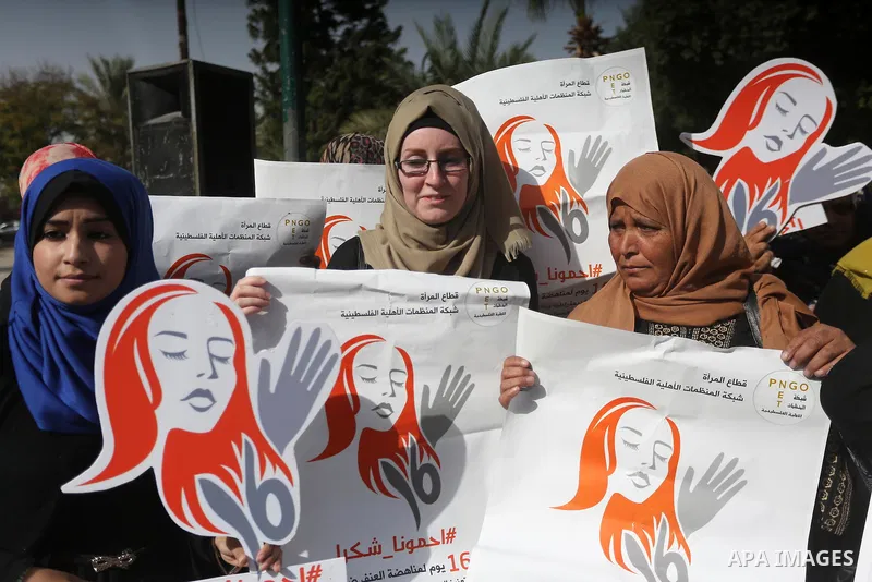 Palestinian women hold banners during international campaign against violence against women, in Gaza City, on November 24, 2016. Photo by Mohammed Asad