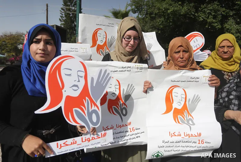 Palestinian women hold banners during international campaign against violence against women, in Gaza City, on November 24, 2016. Photo by Mohammed Asad