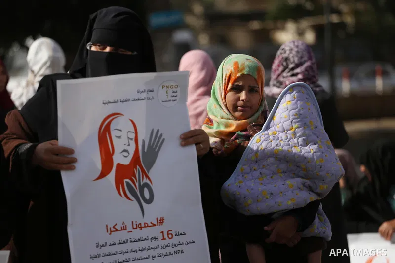 Palestinian women hold banners during international campaign against violence against women, in Gaza City, on November 24, 2016. Photo by Mohammed Asad