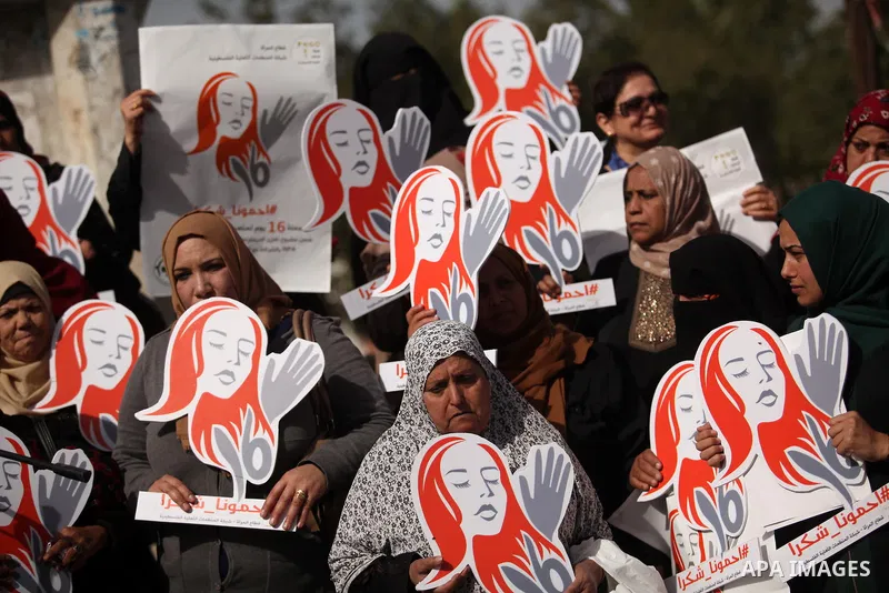 Palestinian women hold banners during international campaign against violence against women, in Gaza City, on November 24, 2016. Photo by Ashraf Amra