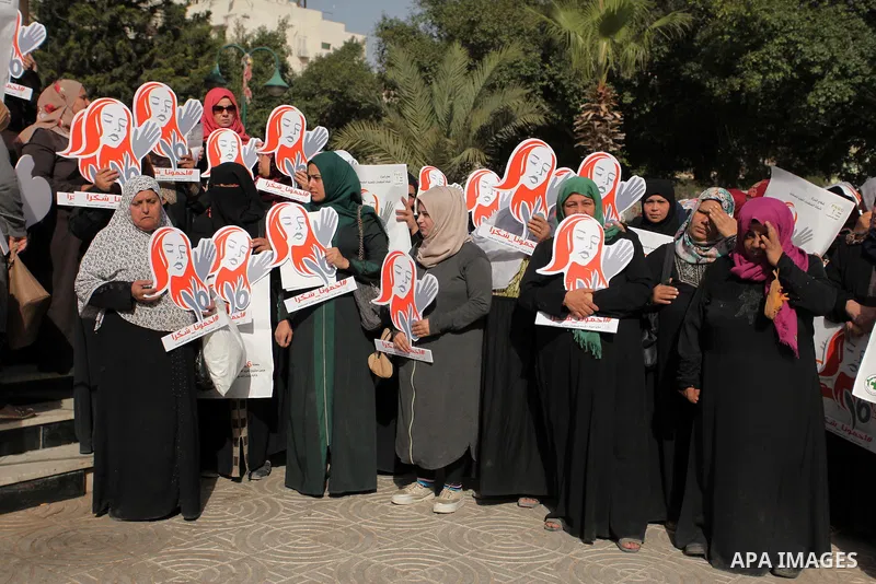 Palestinian women hold banners during international campaign against violence against women, in Gaza City, on November 24, 2016. Photo by Ashraf Amra