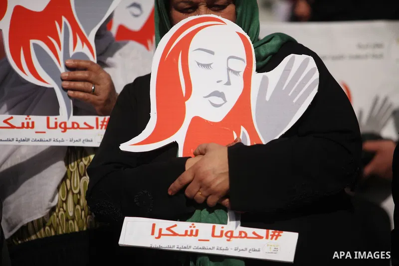 Palestinian women hold banners during international campaign against violence against women, in Gaza City, on November 24, 2016. Photo by Ashraf Amra